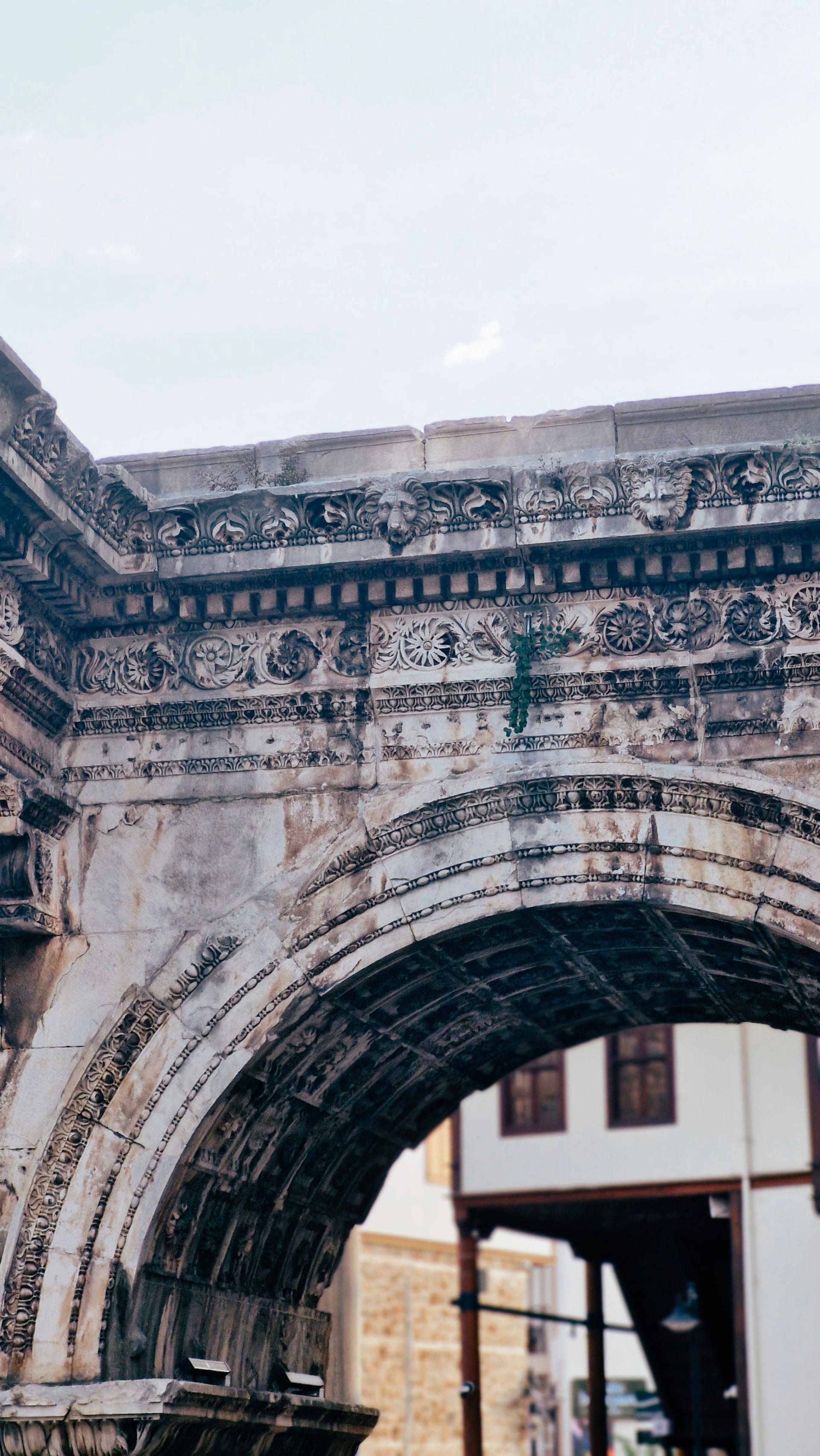 Pale stone arch with carved cornices and a coffered underside.