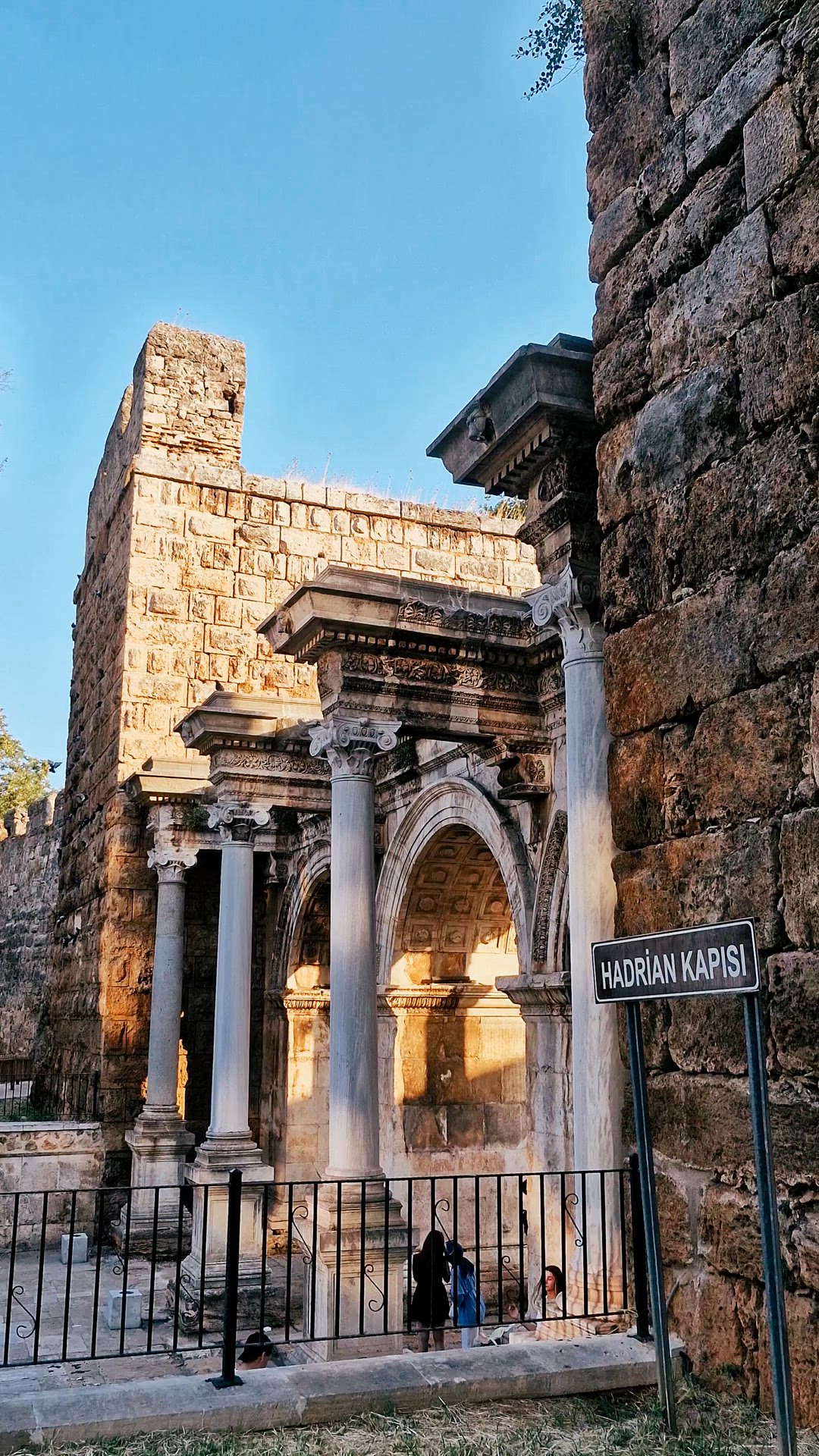 Video moving along the gate's columns, arches and adjacent stone tower.