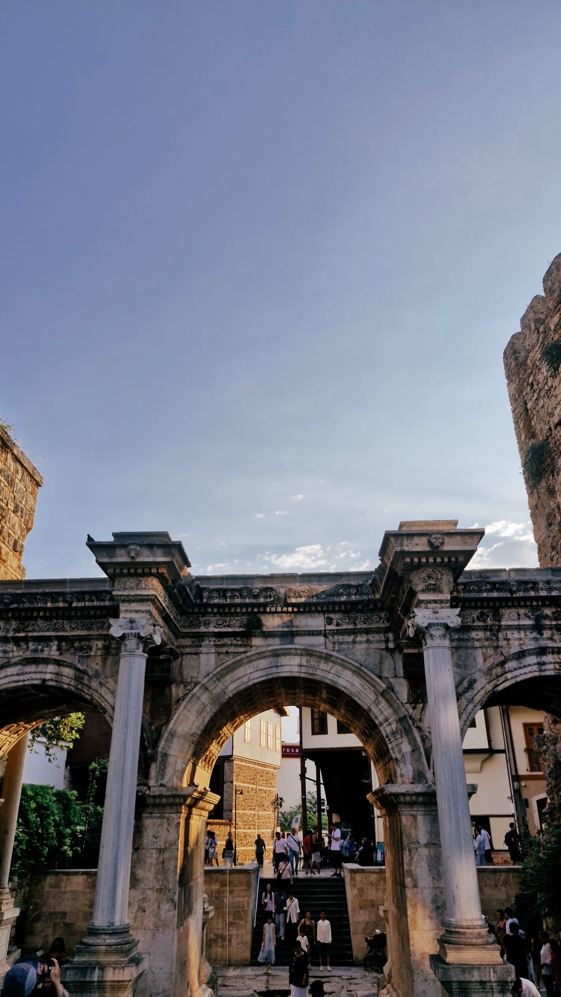 Vertical view of the three arches with visitors passing underneath.
