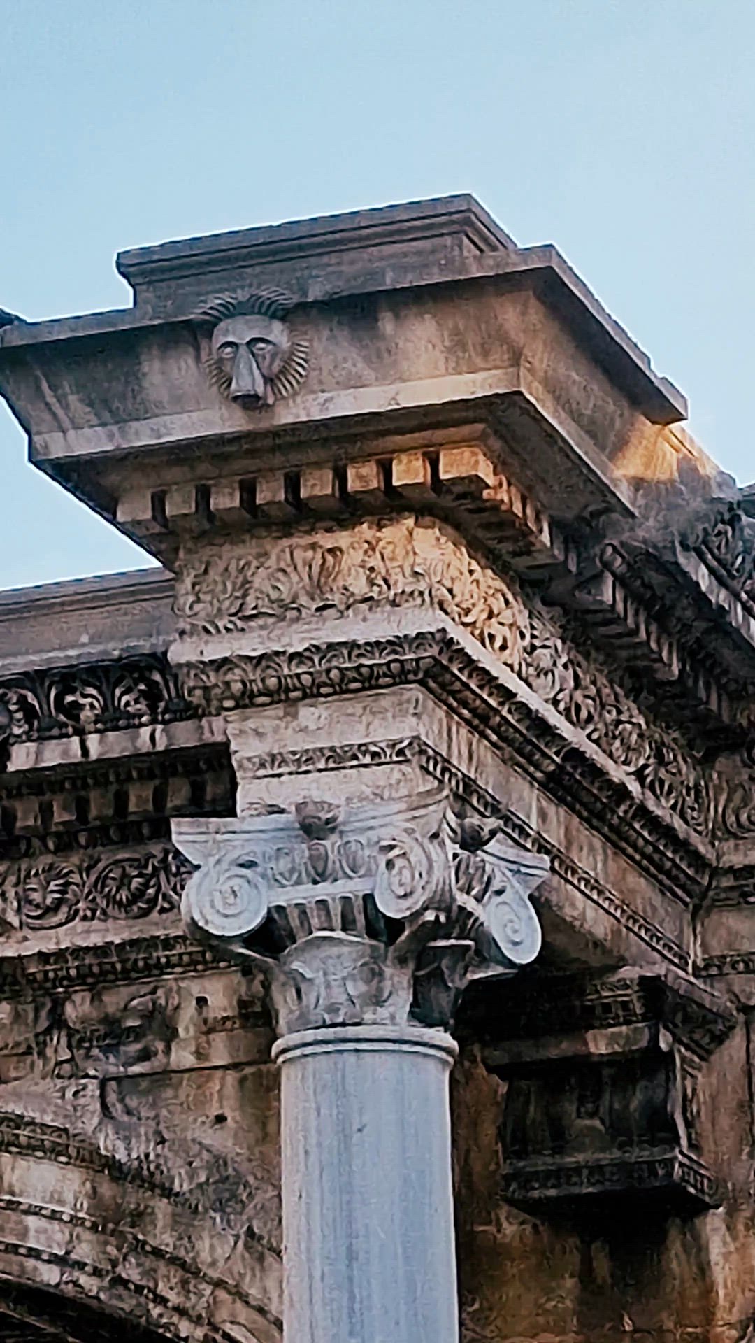 Close video moving across a column capital, carved cornice and arch.