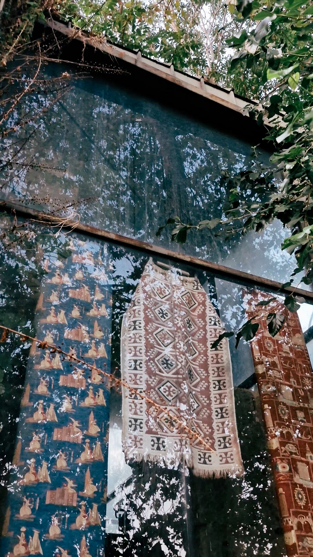 Video moving from patterned textiles behind glass to the minaret and a carved stone doorway.