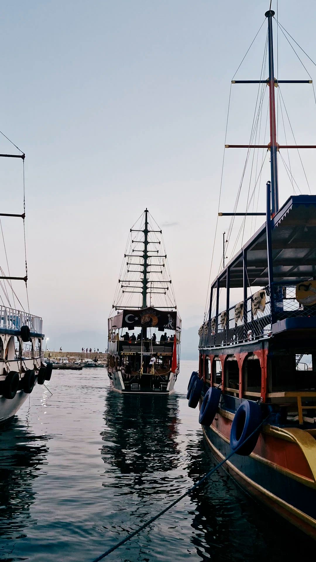 Video of tall-masted tour boats rocking gently in the harbor.