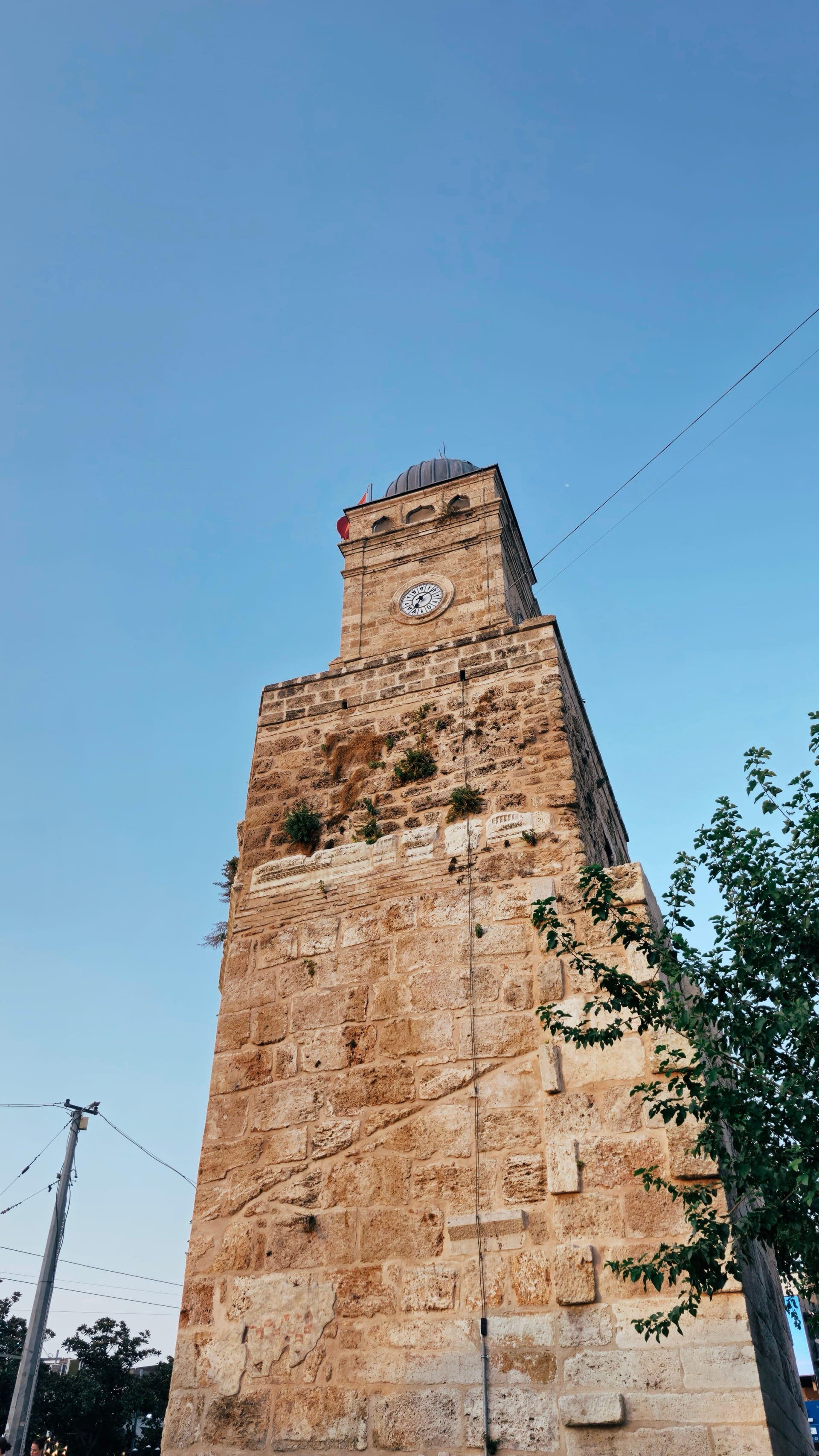 Antalya Clock Tower rising against a clear blue evening sky.